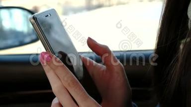 贴身女人`她的手在车里发<strong>手机短信</strong>。 侧视。